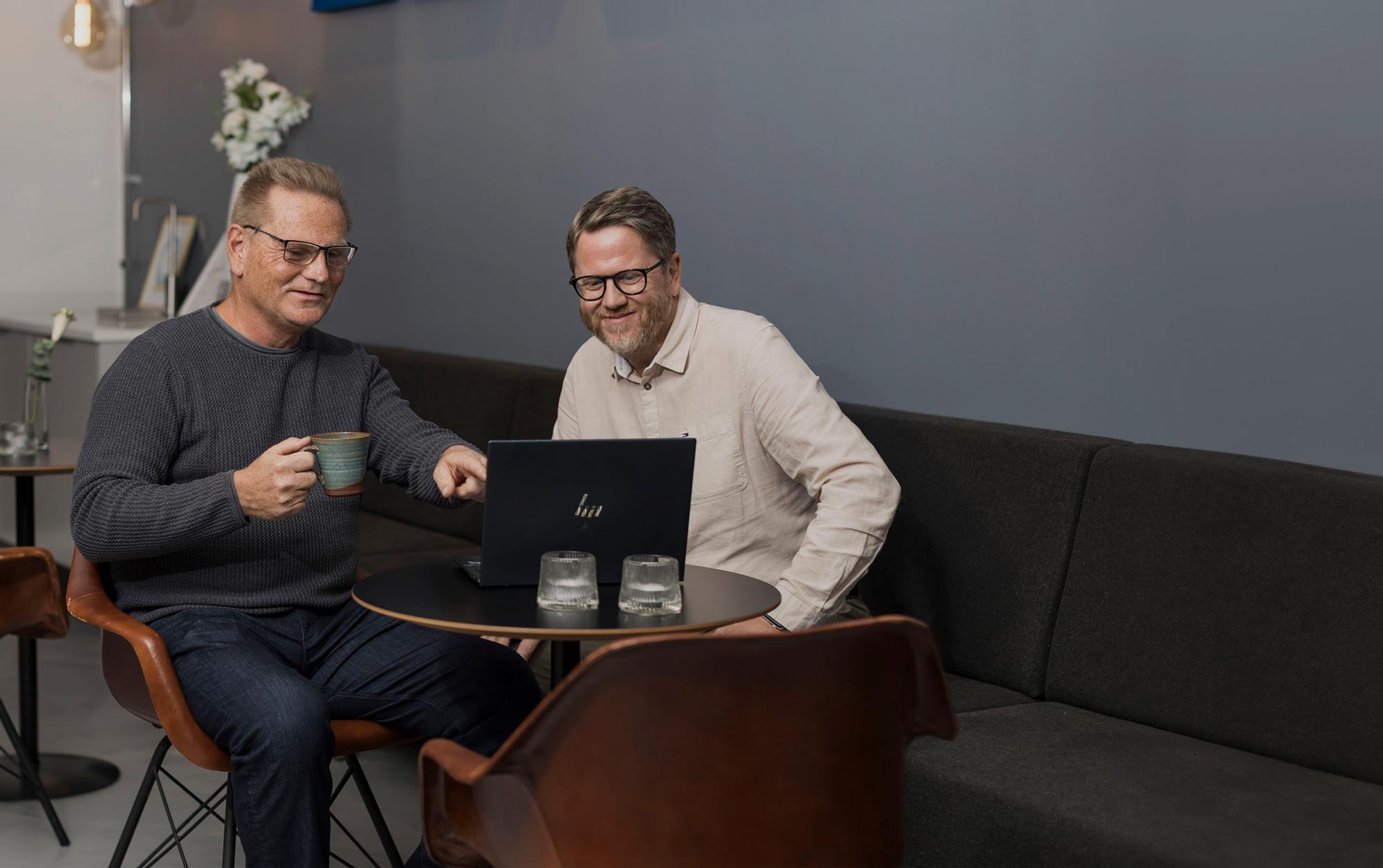 Två anställda pekar på en datorskärm