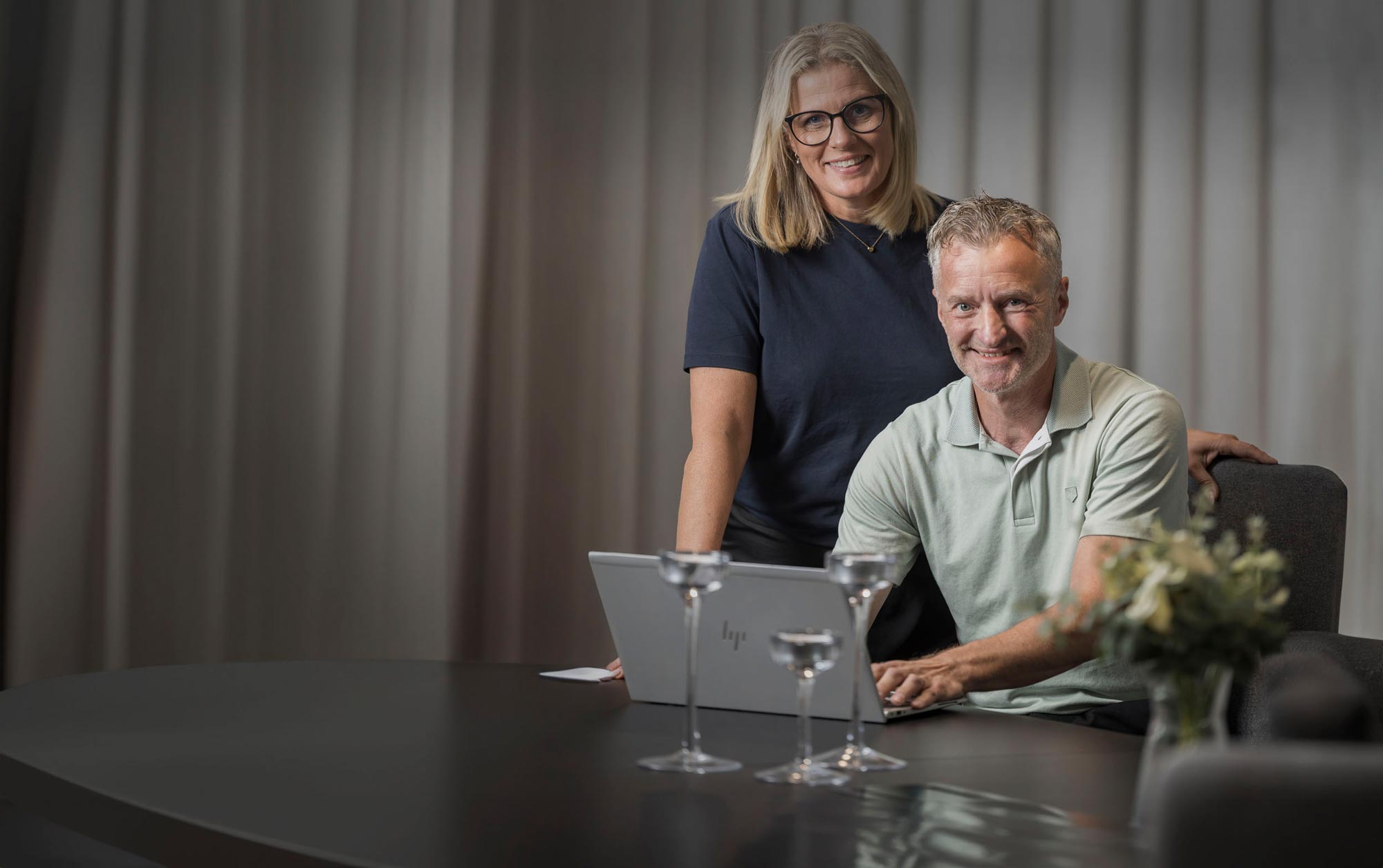 Två anställda tittar in i kameran